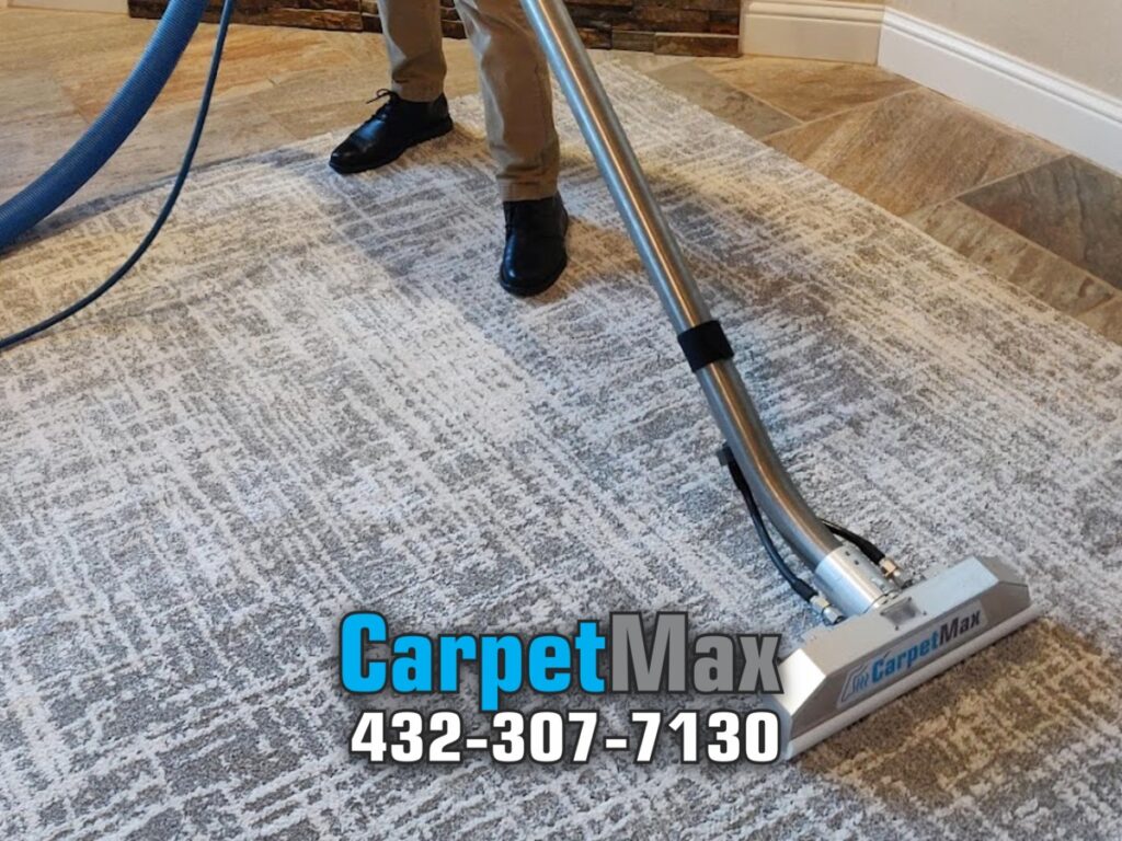 CarpetMax technician steam cleaning a patterned gray area rug in a Midland, TX home